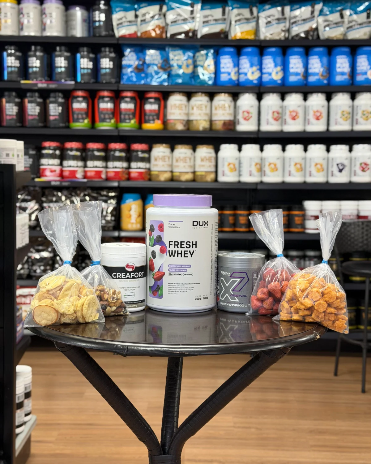 Whey protein, creatina, pré-treino e castanhas a granel sobre mesa na loja Prime Performance Suplementos em Campo Grande MS